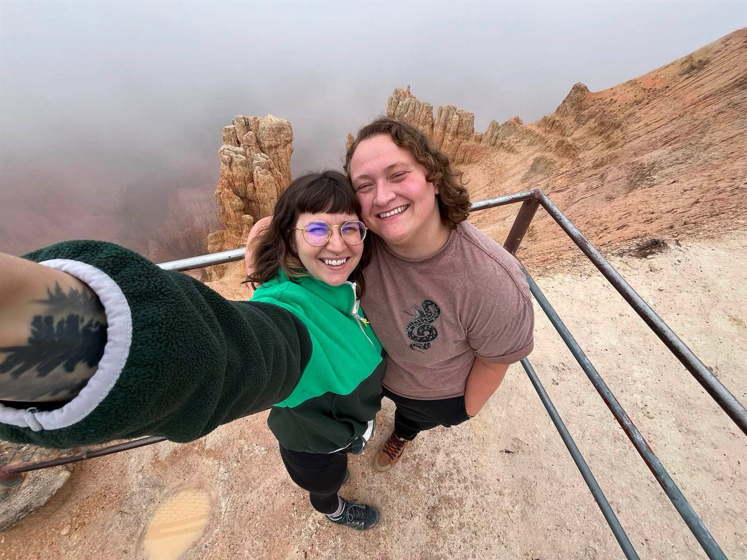 Emily and Baylie smiling together on a canyon overlook